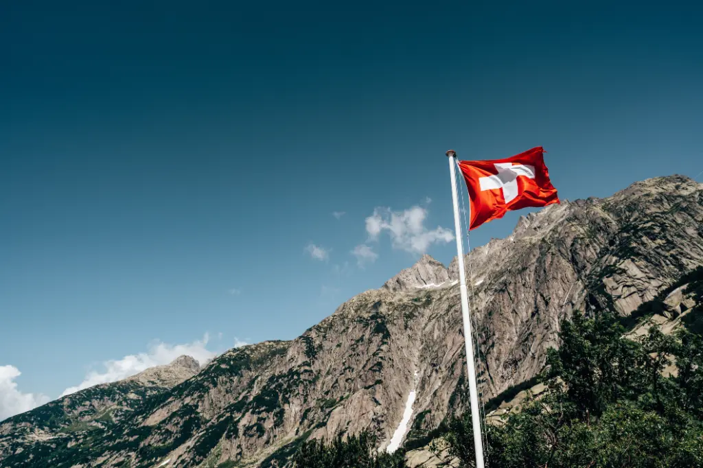 Schweizer Flagge mit Bergen im Hintergrund